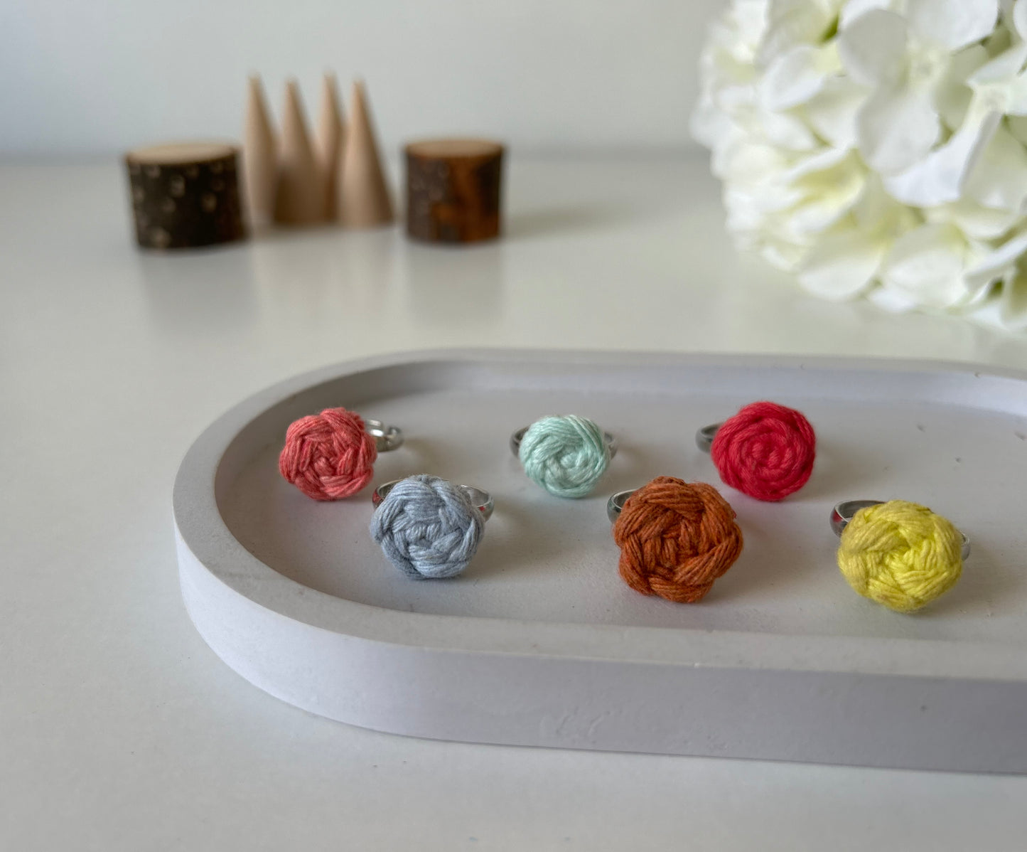 Descubre la belleza y versatilidad de nuestros anillos ajustables de acero inoxidable, decorados con una delicada flor de algodón elaborada con la técnica de macramé. Cada pieza es única y hecha a mano, fusionando el elegante brillo del acero inoxidable con la calidez y textura del algodón.