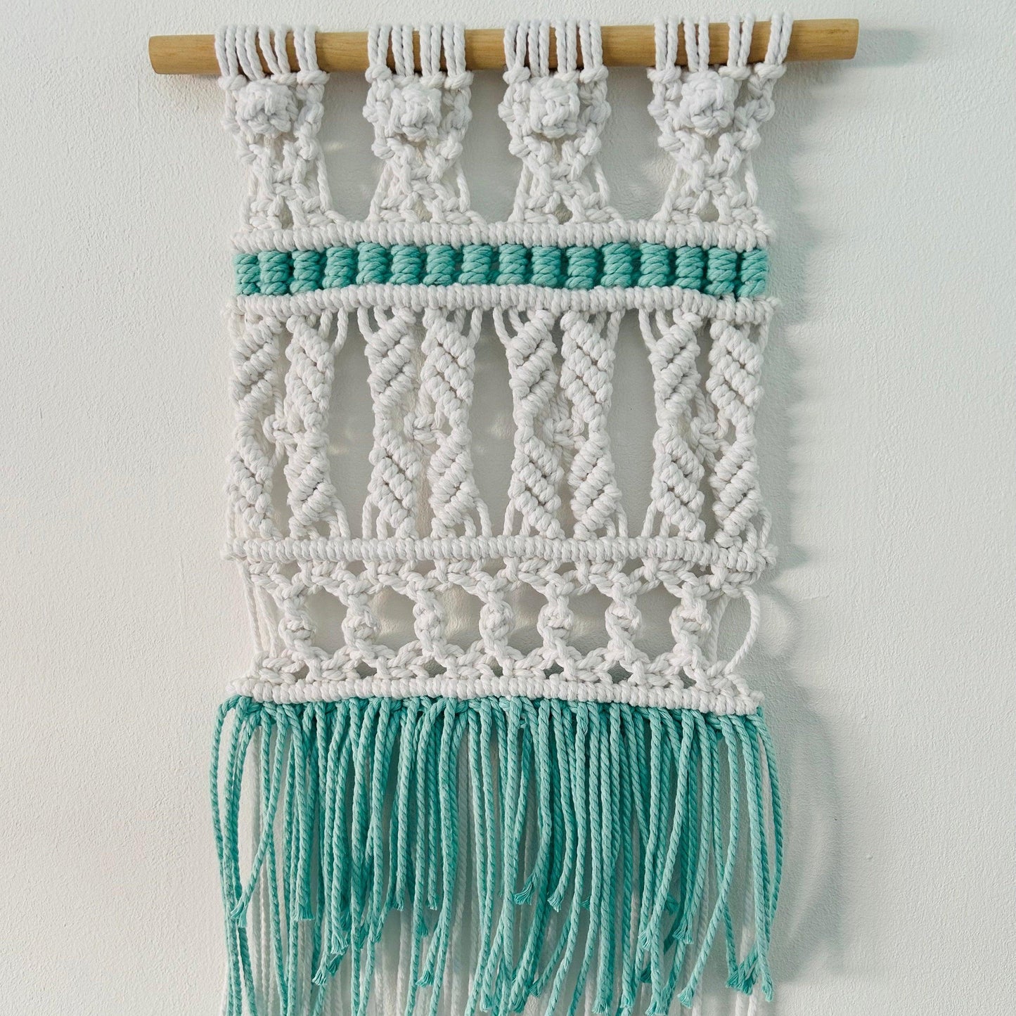 Tapiz tribal de macramé hecho a mano en algodón. Decoración boho y artesanal con toques étnicos para dar calidez y estilo a tu hogar.