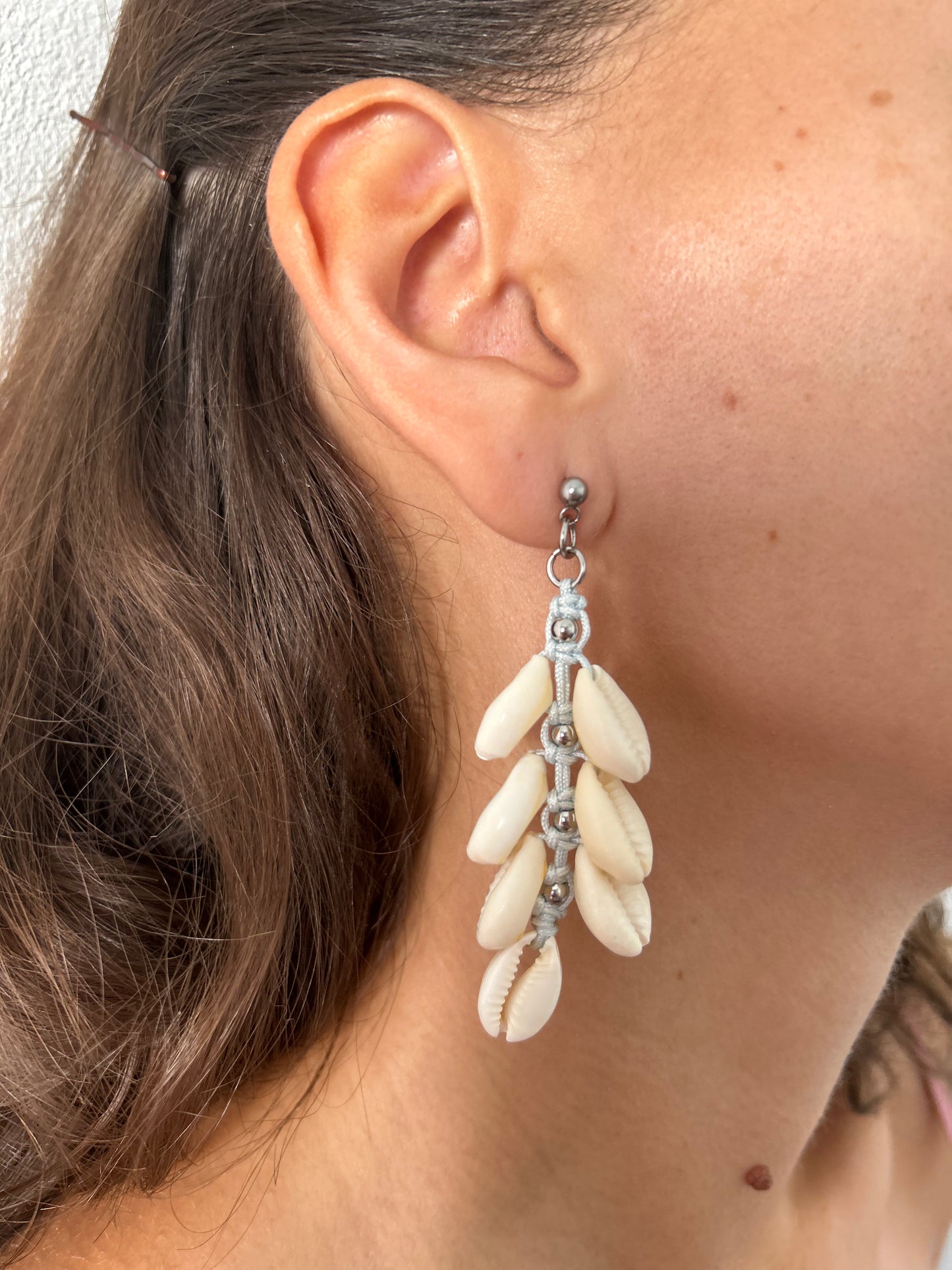 Descubre la belleza y el estilo único de nuestros pendientes de macramé, elaborados con hilo de nailon, conchas naturales y cuentas de acero inoxidable. Diseñados para añadir un toque de sofisticación y frescura a tu look, estos pendientes combinan la artesanía tradicional con materiales modernos para un resultado impresionante.