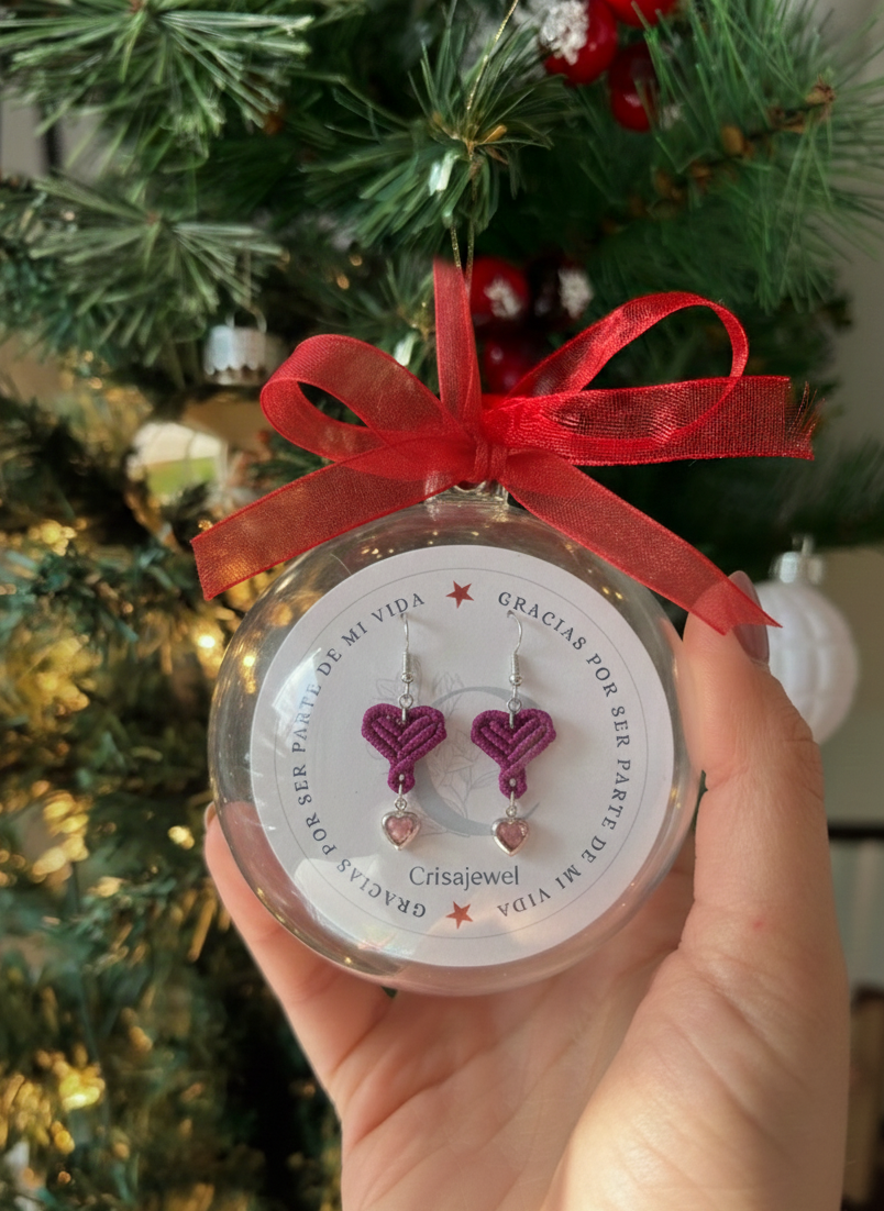 Primer plano de los pendientes de corazón de macramé tejidos a mano con aro plateado.