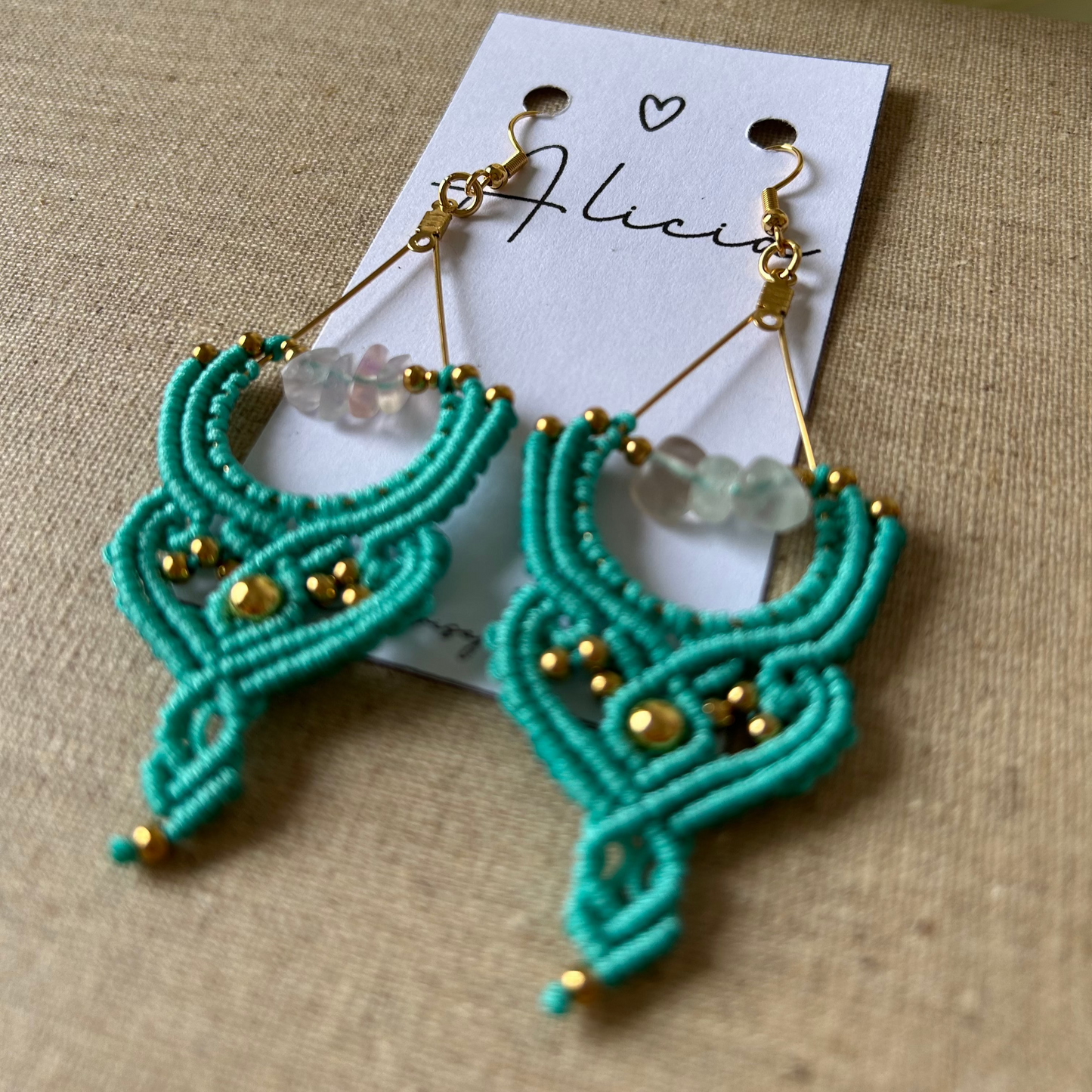 Añade un toque de frescura y sofisticación a tu estilo con los pendientes Cactus, una pieza exclusiva elaborada con la técnica de macramé. Confeccionados con hilo de nailon, cuentas de acero inoxidable y piedras naturales, estos pendientes combinan elegancia y diseño contemporáneo para un acabado único.