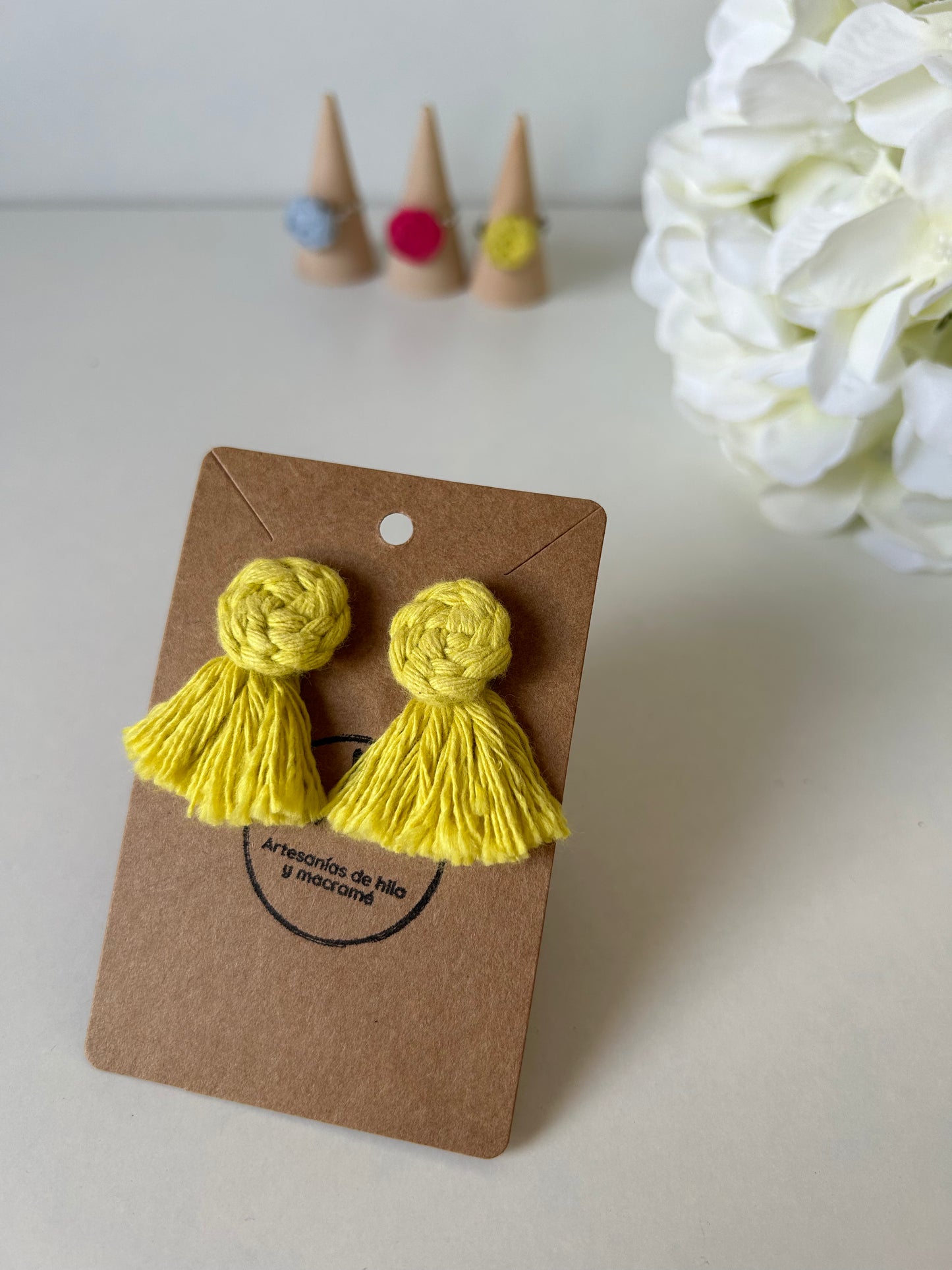 Descubre la sofisticación artesanal con nuestros pendientes Cotton en acero inoxidable, adornados con una flor de algodón y flecos decorativos realizados mediante la técnica de macramé. Estas joyas únicas combinan la elegancia moderna con un toque bohemio, haciendo de cada par una expresión de arte y estilo.
