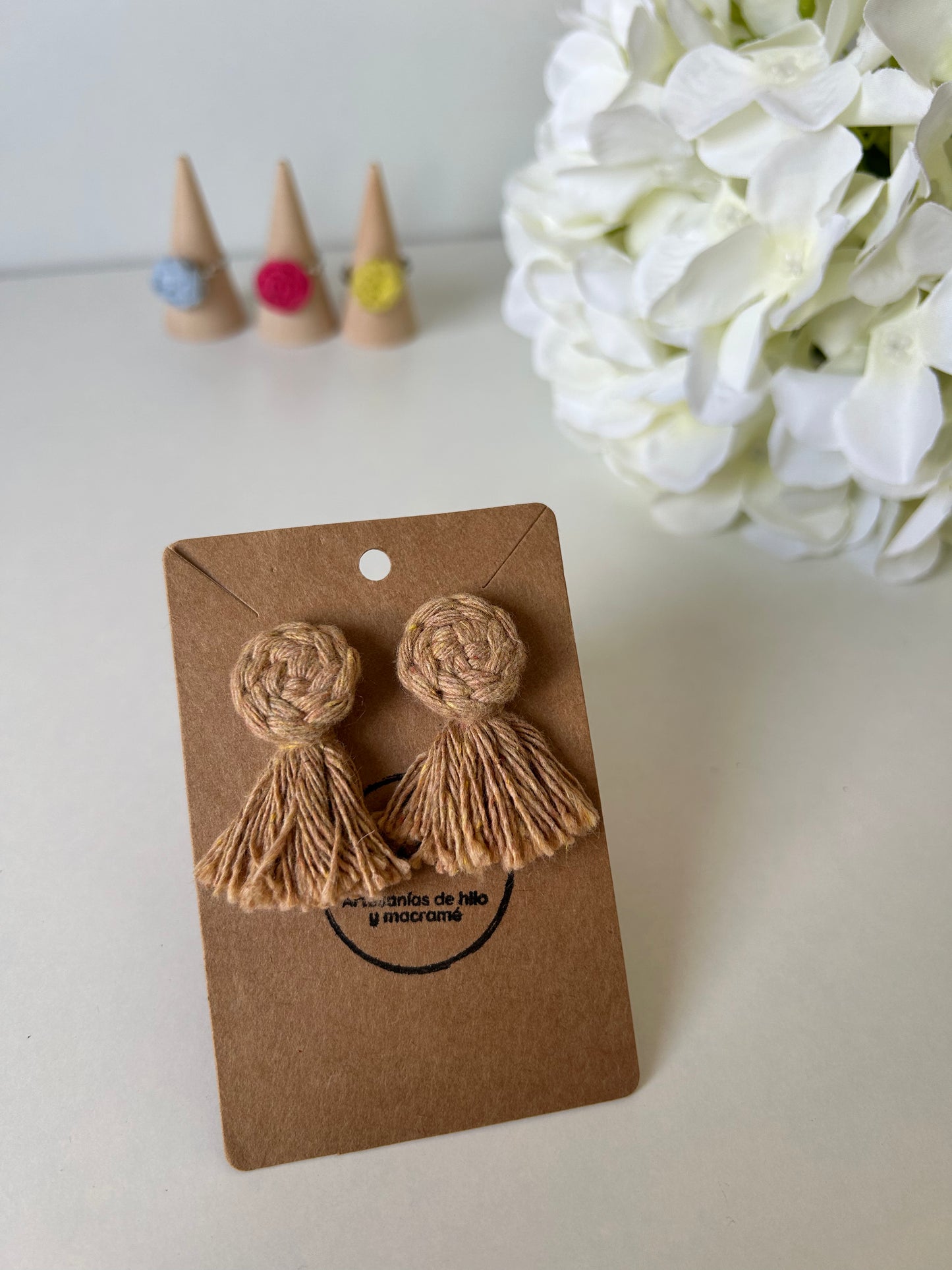Descubre la sofisticación artesanal con nuestros pendientes Cotton en acero inoxidable, adornados con una flor de algodón y flecos decorativos realizados mediante la técnica de macramé. Estas joyas únicas combinan la elegancia moderna con un toque bohemio, haciendo de cada par una expresión de arte y estilo.