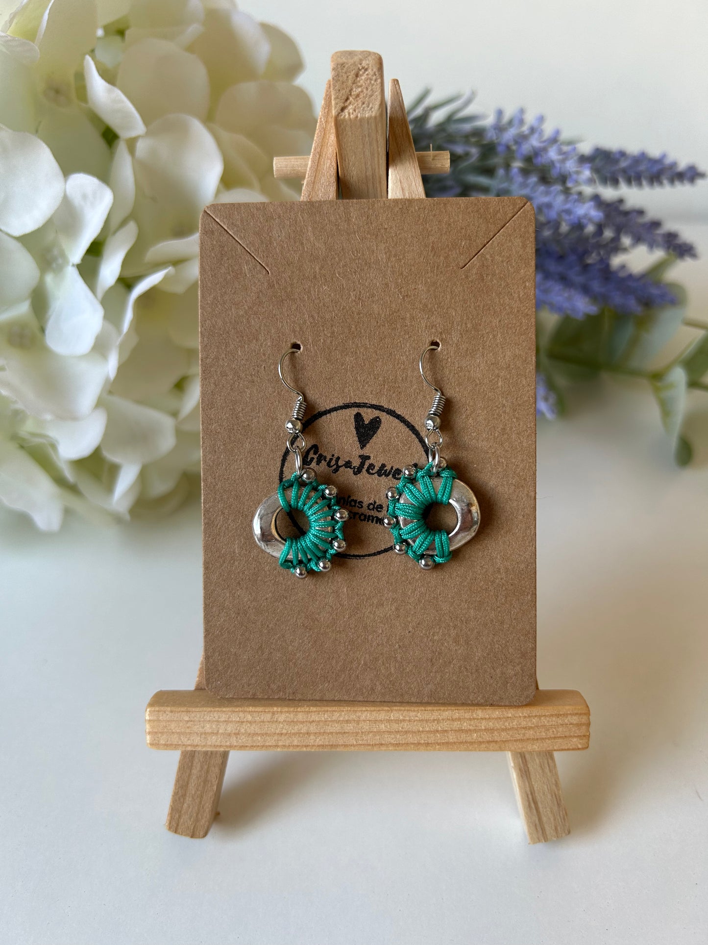 Descubre la sofisticación y el estilo atemporal con nuestros pendientes Media Luna Radiante. Estos pendientes están elaborados a mano utilizando la técnica de macramé, destacando un diseño circular en acero inoxidable que combina artesanía tradicional con un toque moderno y elegante.