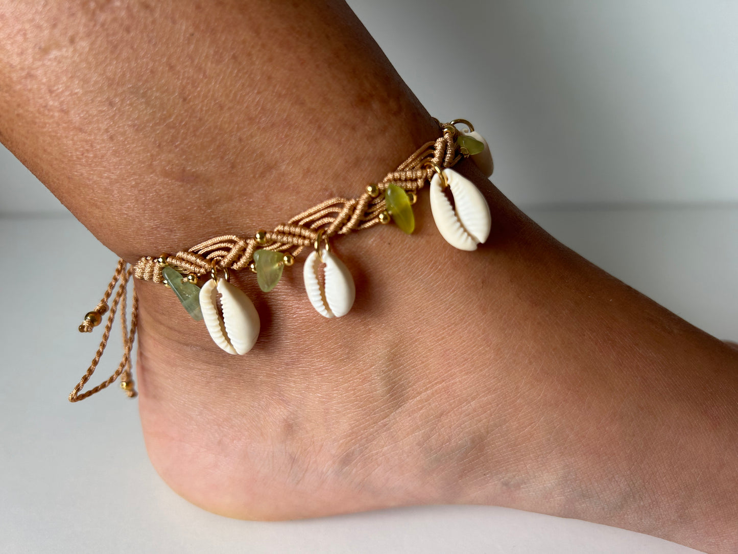 Descubre la esencia del verano y la elegancia natural con la Tobillera Brisa Marina. Diseñada para capturar la frescura y la belleza de la playa, esta tobillera está elaborada con hilo de nailon, chips de piedras naturales, conchas y cuentas de acero inoxidable, creando una pieza única y sofisticada que embellecerá tus pies con un toque de naturaleza y estilo.