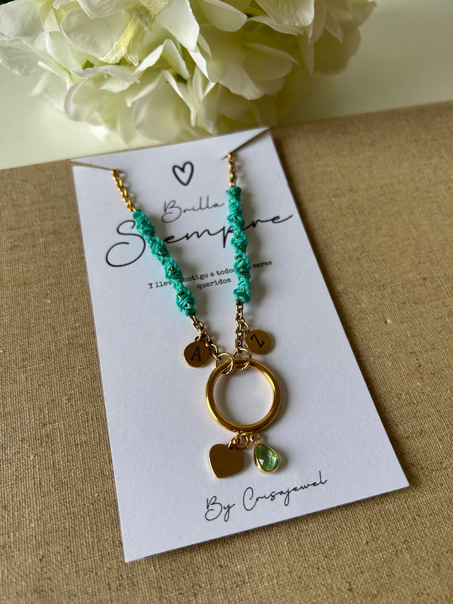 Descubre nuestro elegante pack de joyería, que incluye un colgante personalizable con iniciales de acero inoxidable y un par de pendientes elaborados con la técnica de macramé. Este set es la combinación perfecta de personalización, artesanía y estilo sofisticado.