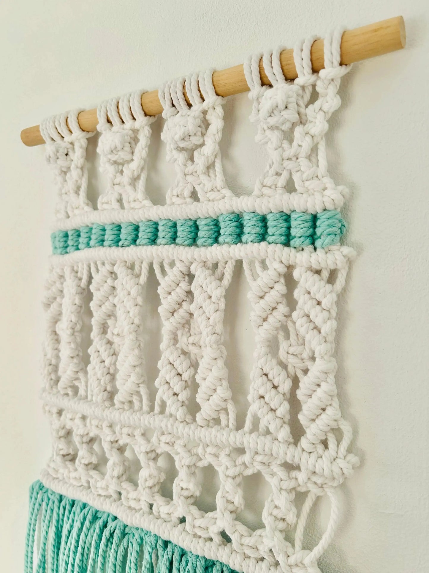 Tapiz tribal de macramé hecho a mano en algodón. Decoración boho y artesanal con toques étnicos para dar calidez y estilo a tu hogar.