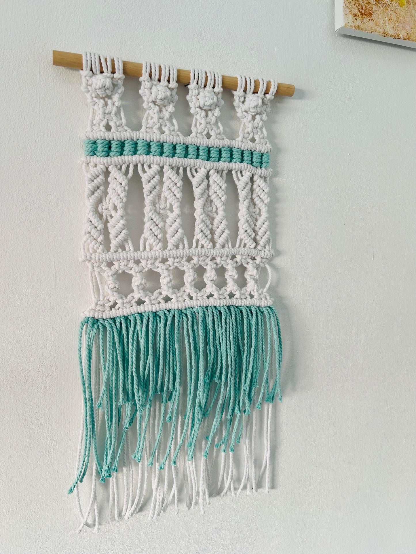 Tapiz tribal de macramé hecho a mano en algodón. Decoración boho y artesanal con toques étnicos para dar calidez y estilo a tu hogar.
