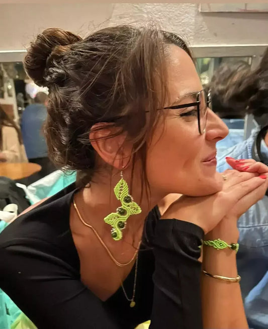 Clienta satisfecha mostrando sus pendientes y pulsera de macramé artesanal de Crisajewel, con una sonrisa de alegría y estilo natural.