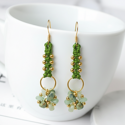 Pendientes artesanales Aura con tejido en hilo, cuentas doradas y racimo de pequeñas piedras naturales en la parte inferior, disponibles en varios colores.