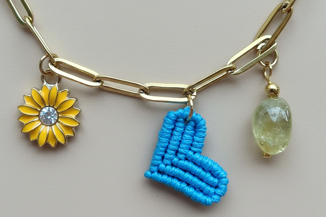 Collar dorado con charms variados en forma de corazón azul tejido, charms de acero. Tendencia 2026