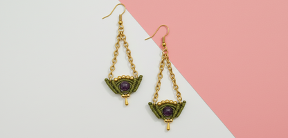 Pendientes artesanales Celeste con cadena dorada, tejido en hilo verde oliva y piedra central oscura.