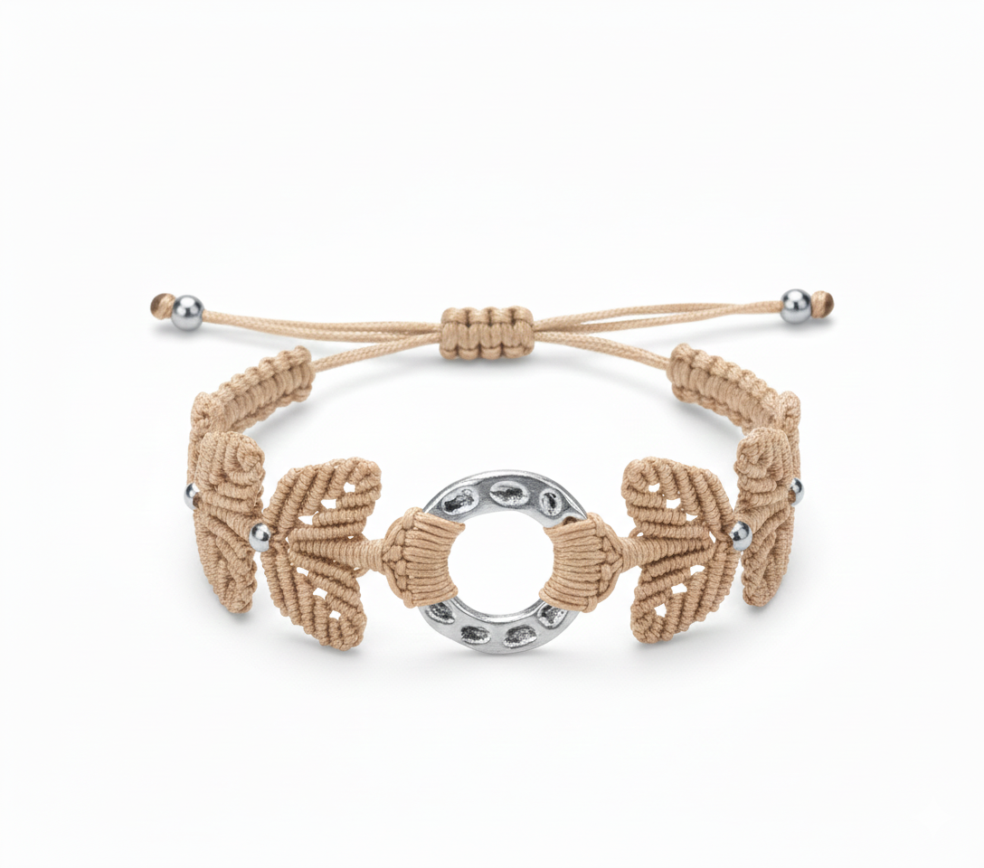 Brazalete artesanal de macramé en beige con pieza central circular metálica y cierre ajustable.