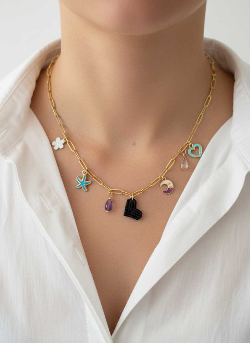 Collar dorado con charms variados en forma de corazón negro tejido, charms de acero. Tendencia 2026