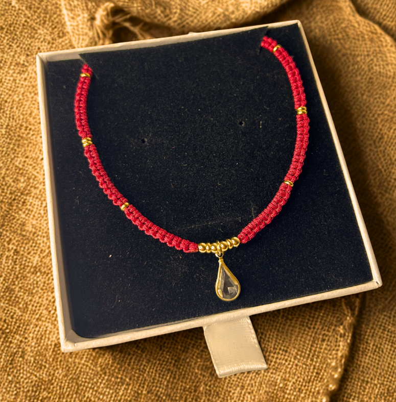 Gargantilla Orión exhibida sobre caja de terciopelo negro, destacando el charm central de gota.