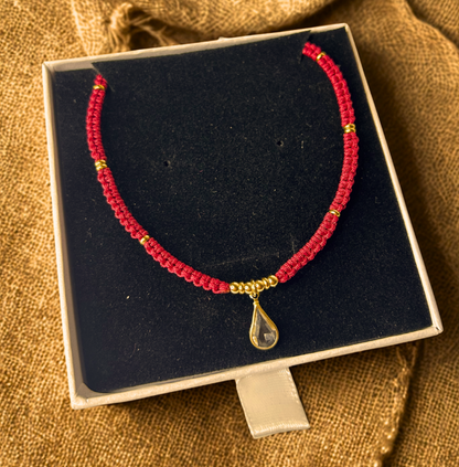 Gargantilla Orión exhibida sobre caja de terciopelo negro, destacando el charm central de gota.