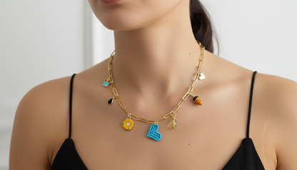 Collar dorado con charms variados en forma de corazón negro tejido, charms de acero. Tendencia 2026