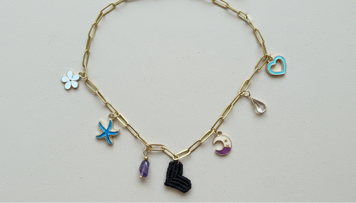 Collar dorado con charms variados en forma de corazón negro tejido, charms de acero. Tendencia 2026