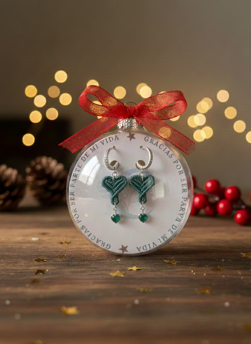 Detalle de los pendientes de macramé azules con dijes de corazón colgantes, presentados como regalo de Navidad.