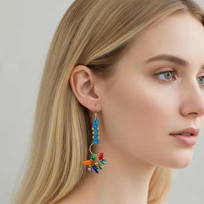 Pendientes artesanales Aura con tejido en hilo, cuentas doradas y racimo de pequeñas piedras naturales en la parte inferior, disponibles en varios colores.