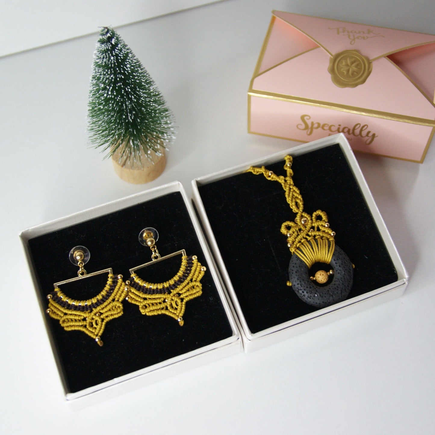 Descubre la fusión perfecta entre artesanía y estilo con nuestro elegante pack de joyería, que incluye un colgante y unos pendientes a juego. Diseñados con una técnica de macramé meticulosa, estos accesorios destacan por su uso de materiales de alta calidad, incluyendo una piedra volcánica y cuentas de acero inoxidable, creando un conjunto que combina sofisticación y originalidad.