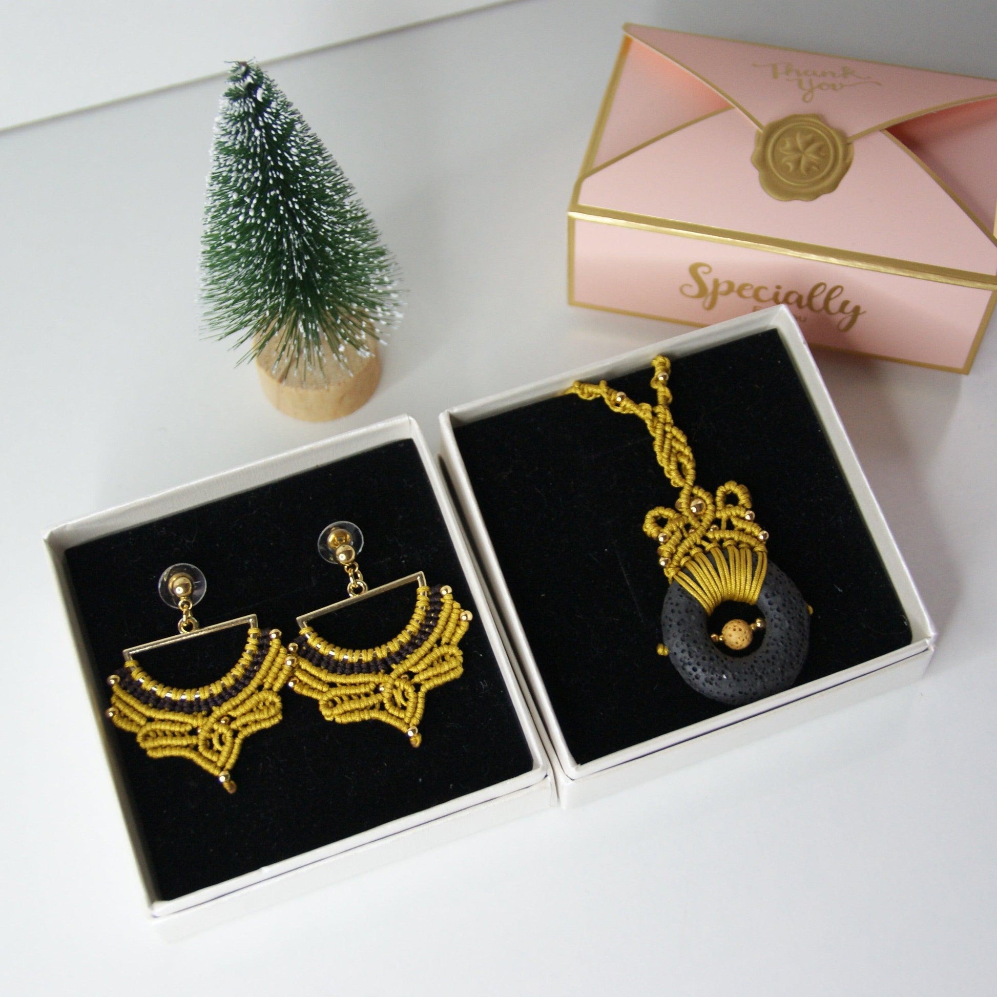 Descubre la fusión perfecta entre artesanía y estilo con nuestro elegante pack de joyería, que incluye un colgante y unos pendientes a juego. Diseñados con una técnica de macramé meticulosa, estos accesorios destacan por su uso de materiales de alta calidad, incluyendo una piedra volcánica y cuentas de acero inoxidable, creando un conjunto que combina sofisticación y originalidad.