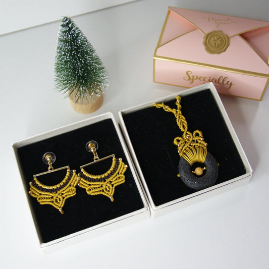 Descubre la fusión perfecta entre artesanía y estilo con nuestro elegante pack de joyería, que incluye un colgante y unos pendientes a juego. Diseñados con una técnica de macramé meticulosa, estos accesorios destacan por su uso de materiales de alta calidad, incluyendo una piedra volcánica y cuentas de acero inoxidable, creando un conjunto que combina sofisticación y originalidad.