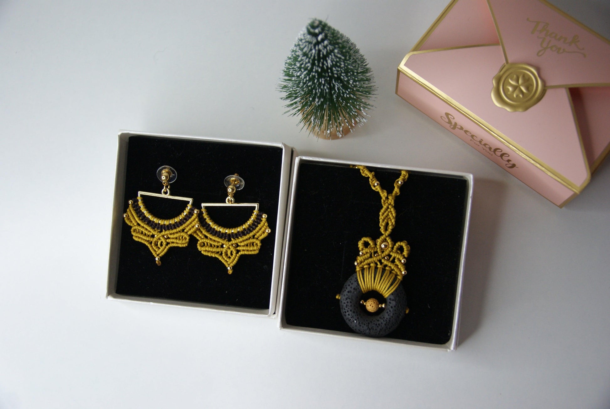 Descubre la fusión perfecta entre artesanía y estilo con nuestro elegante pack de joyería, que incluye un colgante y unos pendientes a juego. Diseñados con una técnica de macramé meticulosa, estos accesorios destacan por su uso de materiales de alta calidad, incluyendo una piedra volcánica y cuentas de acero inoxidable, creando un conjunto que combina sofisticación y originalidad.
