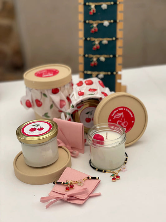 Pack Cereza: vela artesanal de soja con aroma a cereza y pulsera de macramé con charm de cereza en acero inoxidable y cristales facetados.