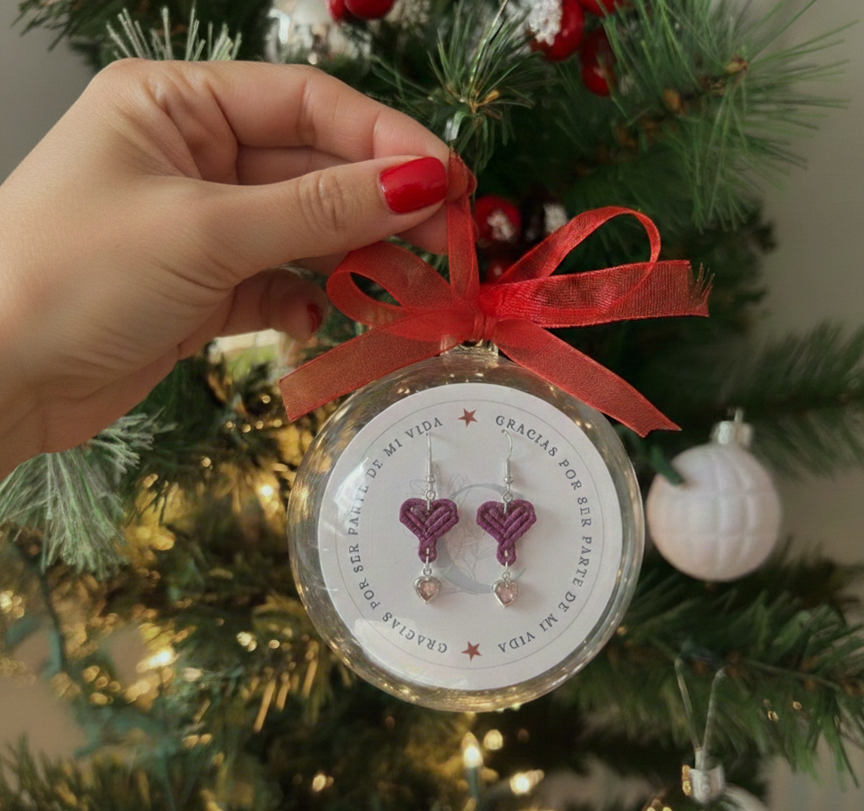 Esfera de regalo navideña con la frase "Gracias por ser parte de mi vida", conteniendo los pendientes de corazón.