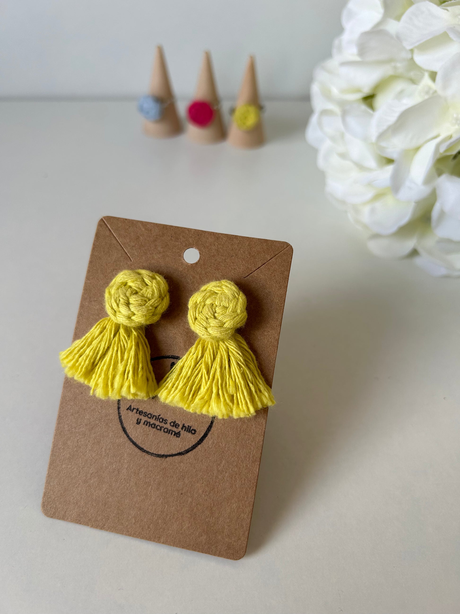Descubre la sofisticación artesanal con nuestros pendientes Cotton en acero inoxidable, adornados con una flor de algodón y flecos decorativos realizados mediante la técnica de macramé. Estas joyas únicas combinan la elegancia moderna con un toque bohemio, haciendo de cada par una expresión de arte y estilo.
