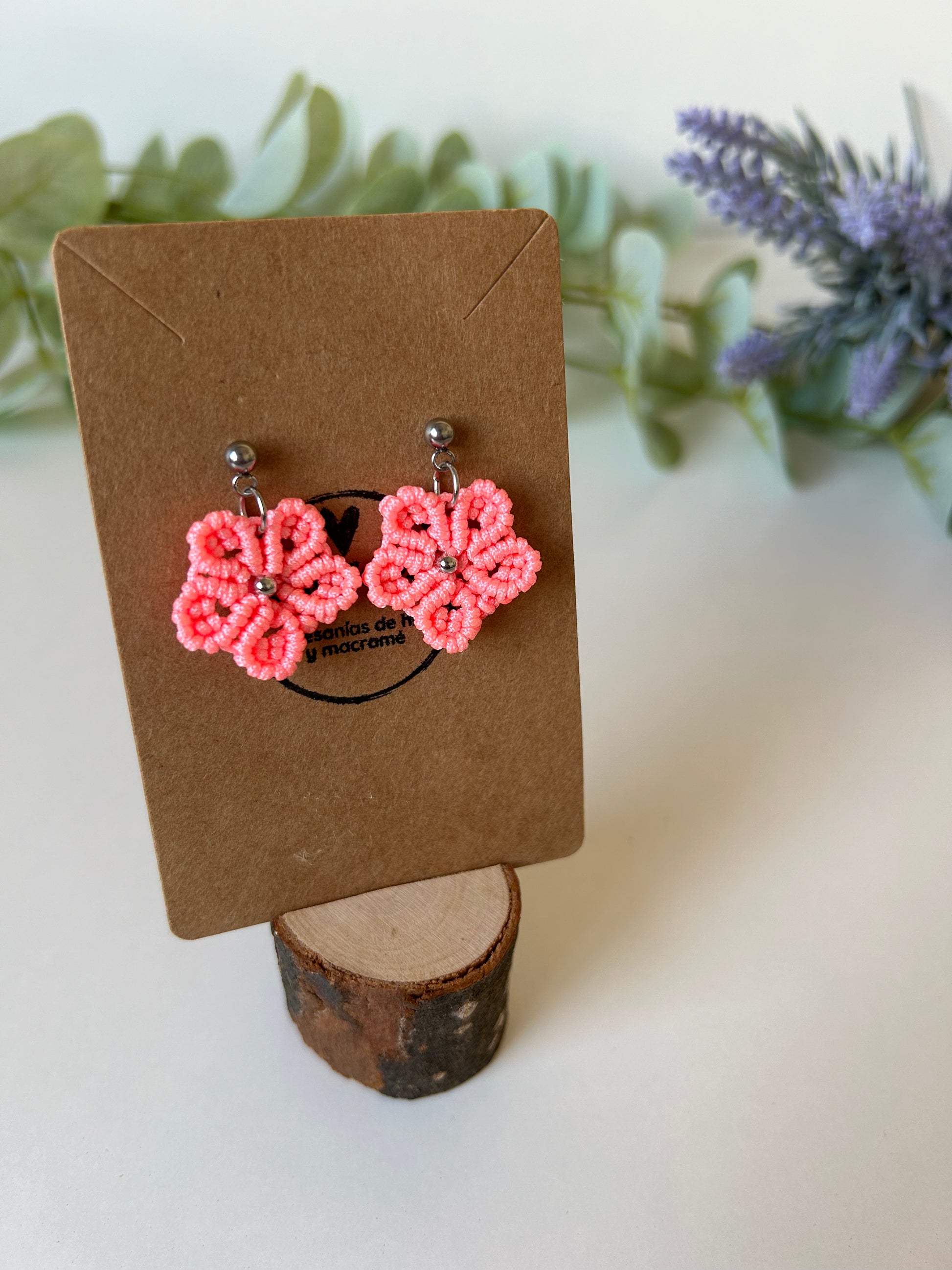 Añade un toque de elegancia natural a tu estilo con los pendientes Floral, una pieza de joyería elaborada con la técnica de macramé. Diseñados con hilo de nailon y detalles en acero inoxidable, estos pendientes en forma de flor son la combinación perfecta de sofisticación y creatividad.