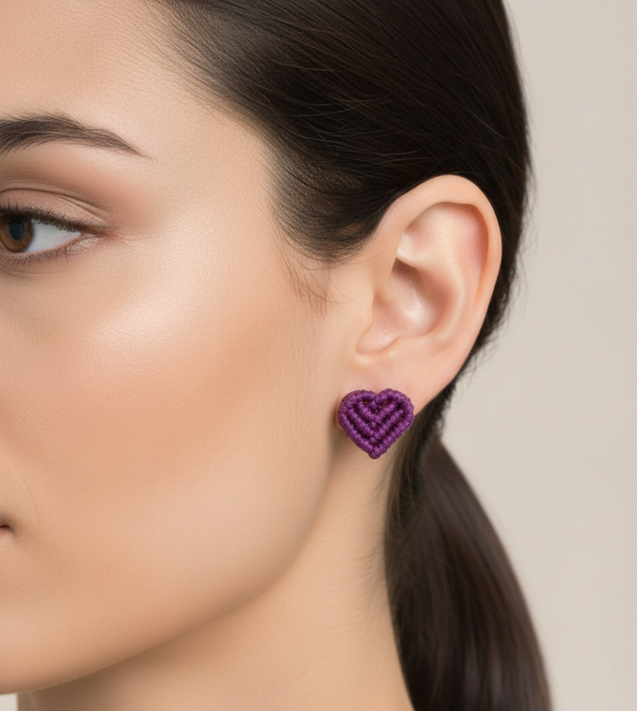 Detalle de pendientes artesanales en forma de corazón, hechos a mano en macramé. Un complemento delicado y original para cualquier ocasión.