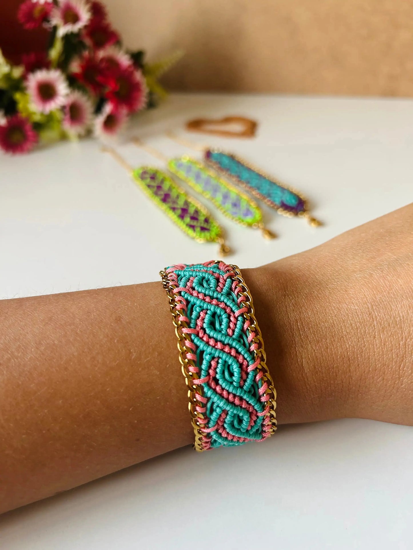 Brazalete de macramé hecho a mano con diseño geométrico, tonos vibrantes inspirados en el mar, joyería artesanal con cadena dorada