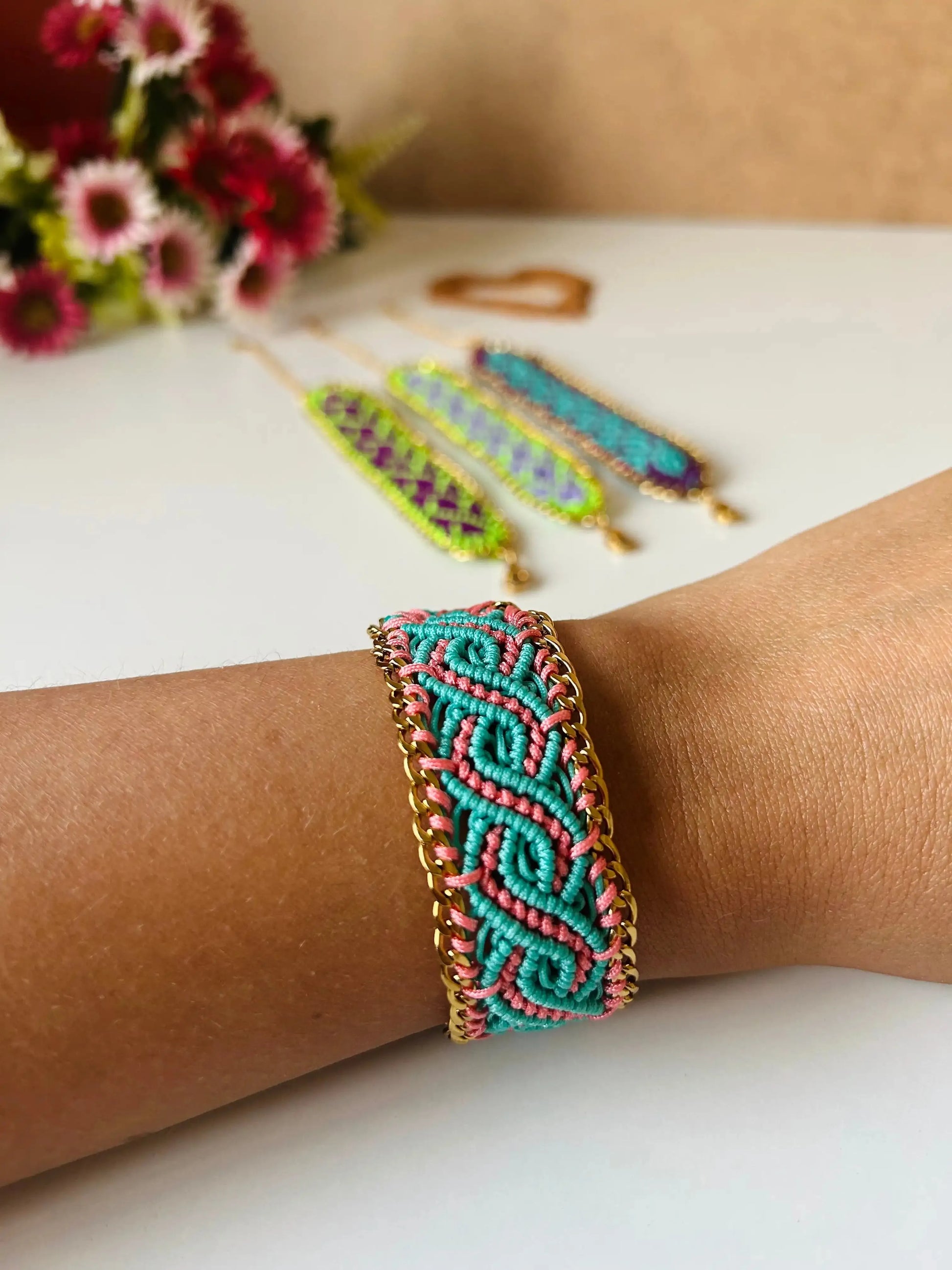 Brazalete de macramé hecho a mano con diseño geométrico, tonos vibrantes inspirados en el mar, joyería artesanal con cadena dorada