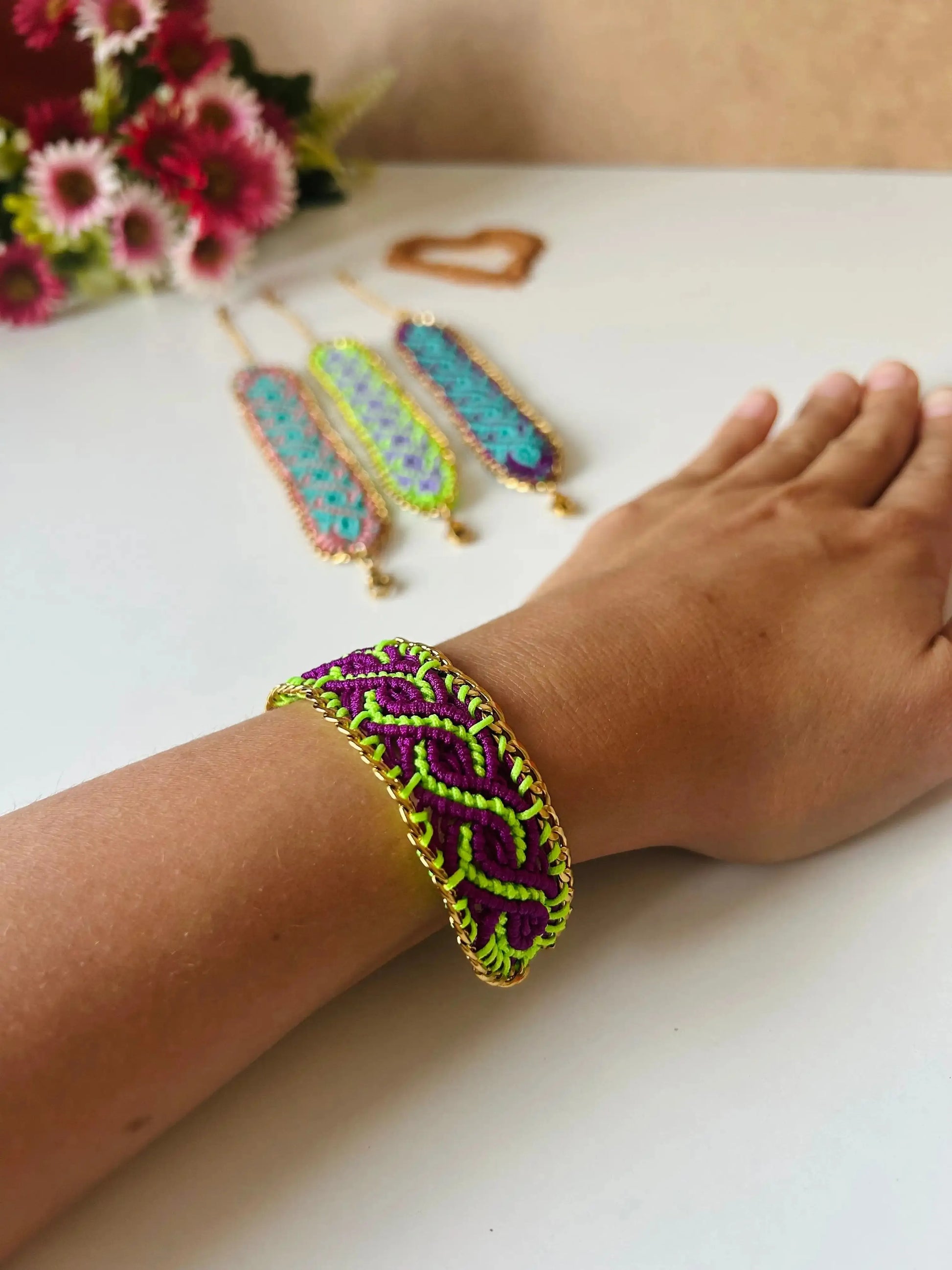 Brazalete de macramé hecho a mano con diseño geométrico, tonos vibrantes inspirados en el mar, joyería artesanal con cadena dorada