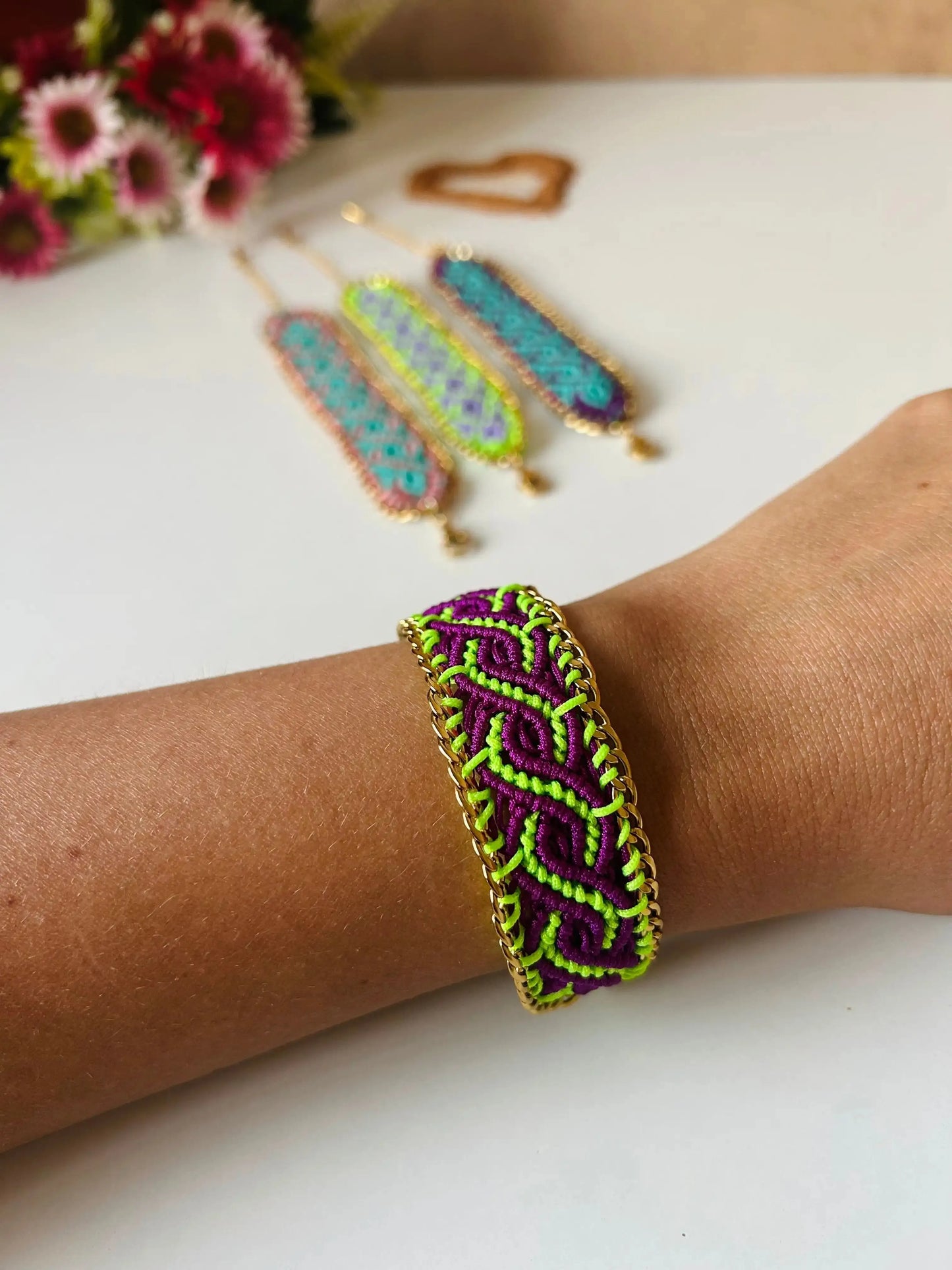 Brazalete de macramé hecho a mano con diseño geométrico, tonos vibrantes inspirados en el mar, joyería artesanal con cadena dorada