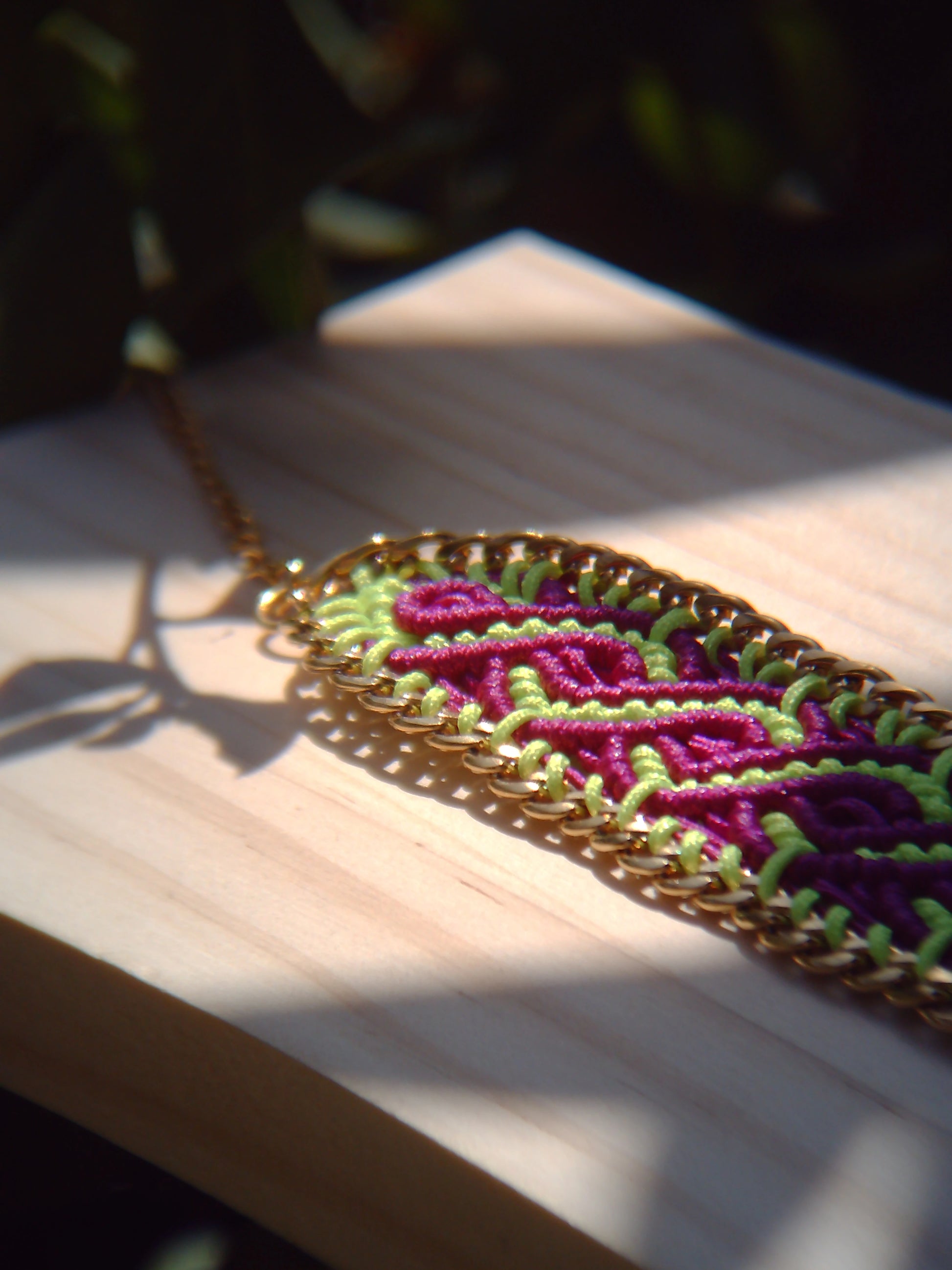 Brazalete de macramé hecho a mano con diseño geométrico, tonos vibrantes inspirados en el mar, joyería artesanal con cadena dorada