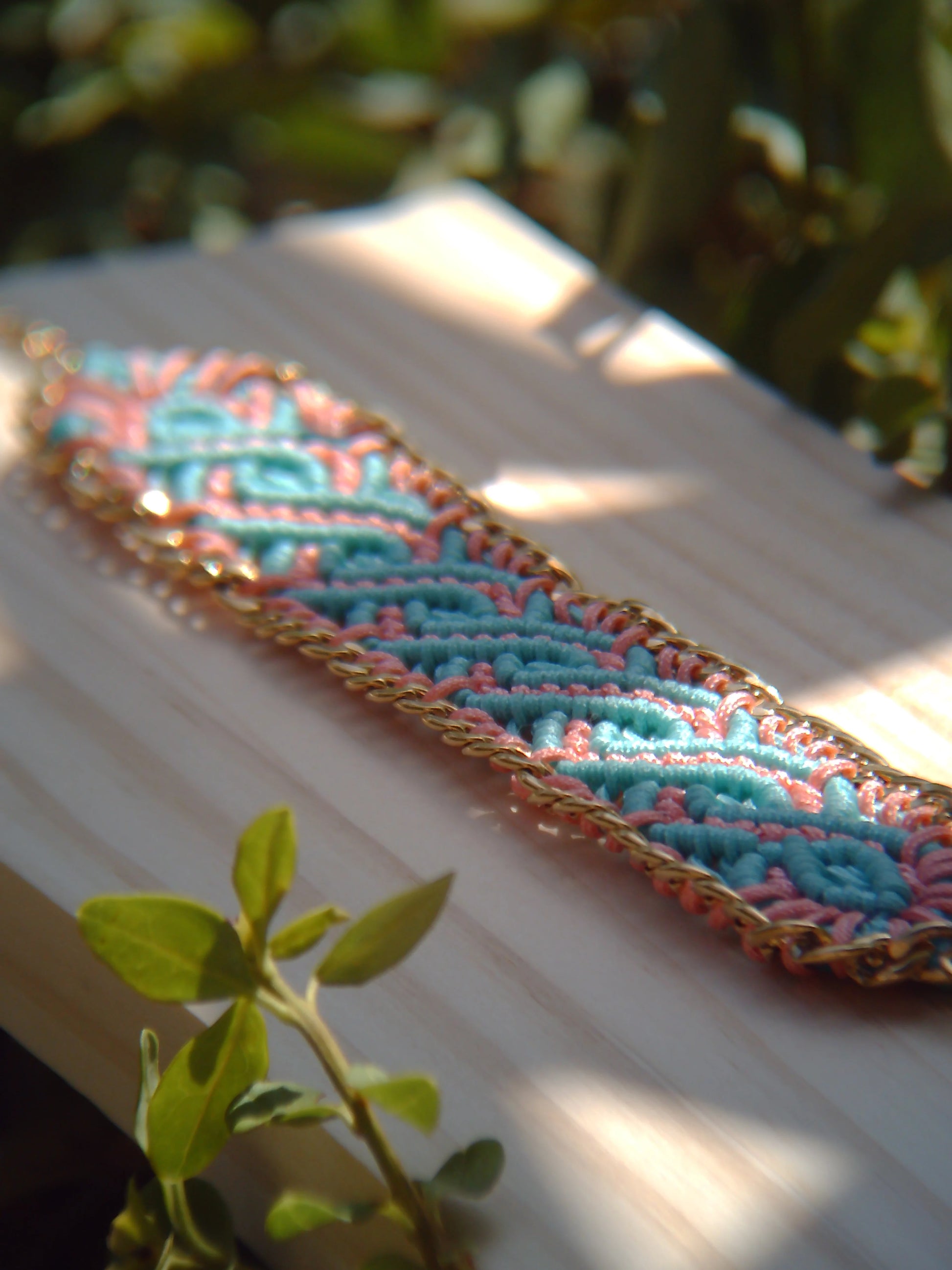Brazalete de macramé hecho a mano con diseño geométrico, tonos vibrantes inspirados en el mar, joyería artesanal con cadena dorada