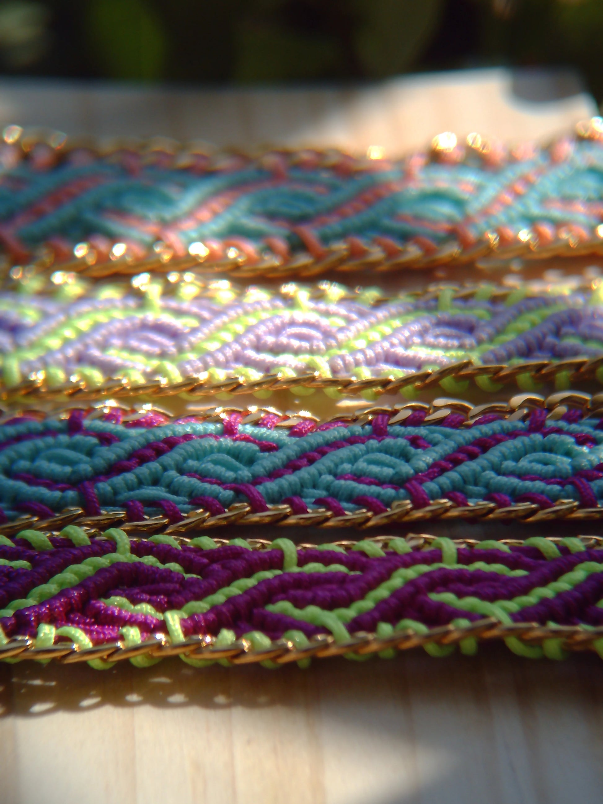 Brazalete de macramé hecho a mano con diseño geométrico, tonos vibrantes inspirados en el mar, joyería artesanal con cadena dorada