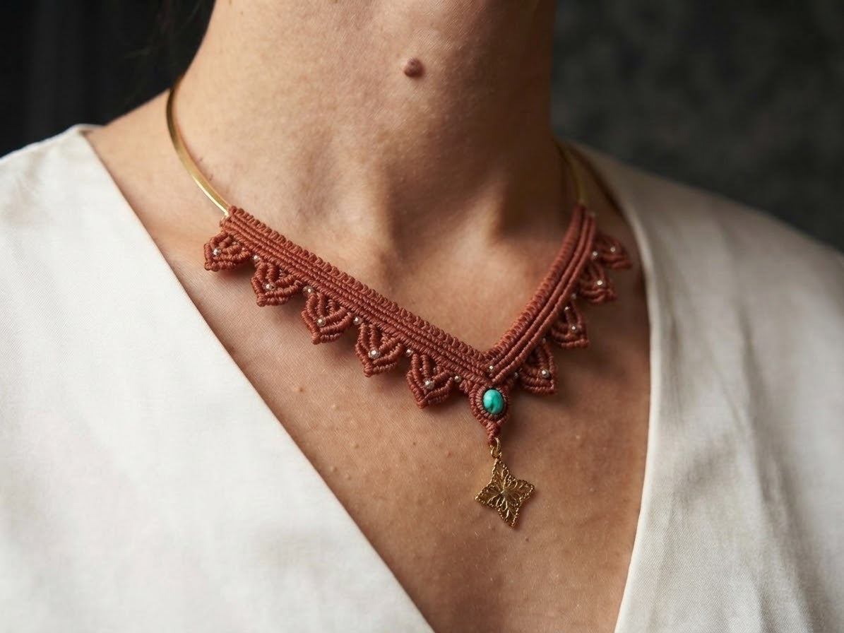 Mujer luciendo collar de macramé terracota con piedra turquesa y colgante dorado sobre gargantilla metálica