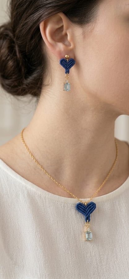 Modelo luciendo collar y pendientes de corazón azul con colgante de piedra y cadena dorada, primer plano