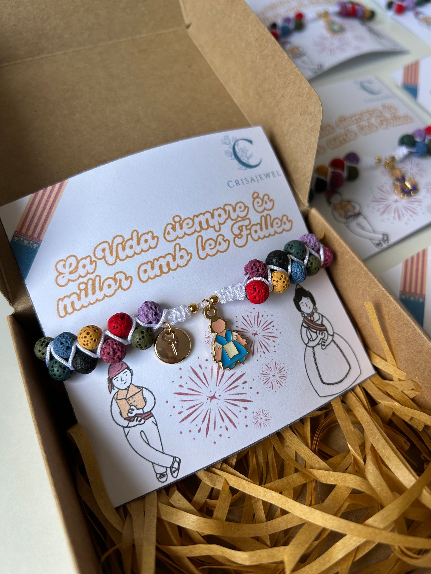 Pulsera Ofrenda ajustable con hilo de nailon, piedras volcánicas y charm de fallera en acero inoxidable, personalizable con inicial.