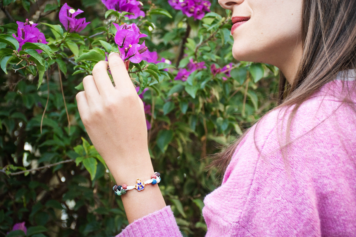 Pulsera Ofrenda ajustable con hilo de nailon, piedras volcánicas y charm de fallera en acero inoxidable, personalizable con inicial.