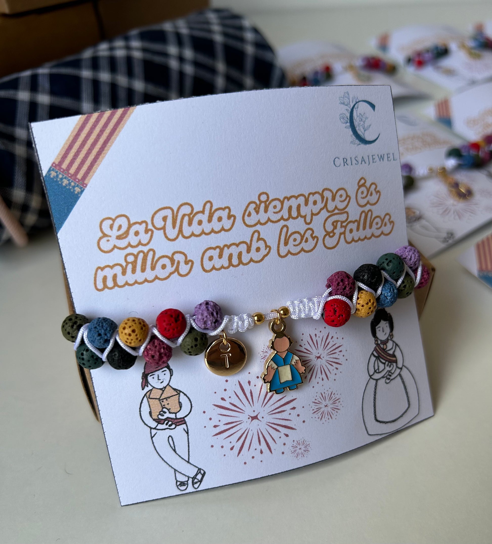Pulsera Ofrenda ajustable con hilo de nailon, piedras volcánicas y charm de fallera en acero inoxidable, personalizable con inicial.